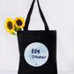 A black tote bag with a cloud-blue circular print that reads 'Big Dreamer'.