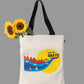 Tote bag with 'City of Ghats' design and sunflowers on a light gray background