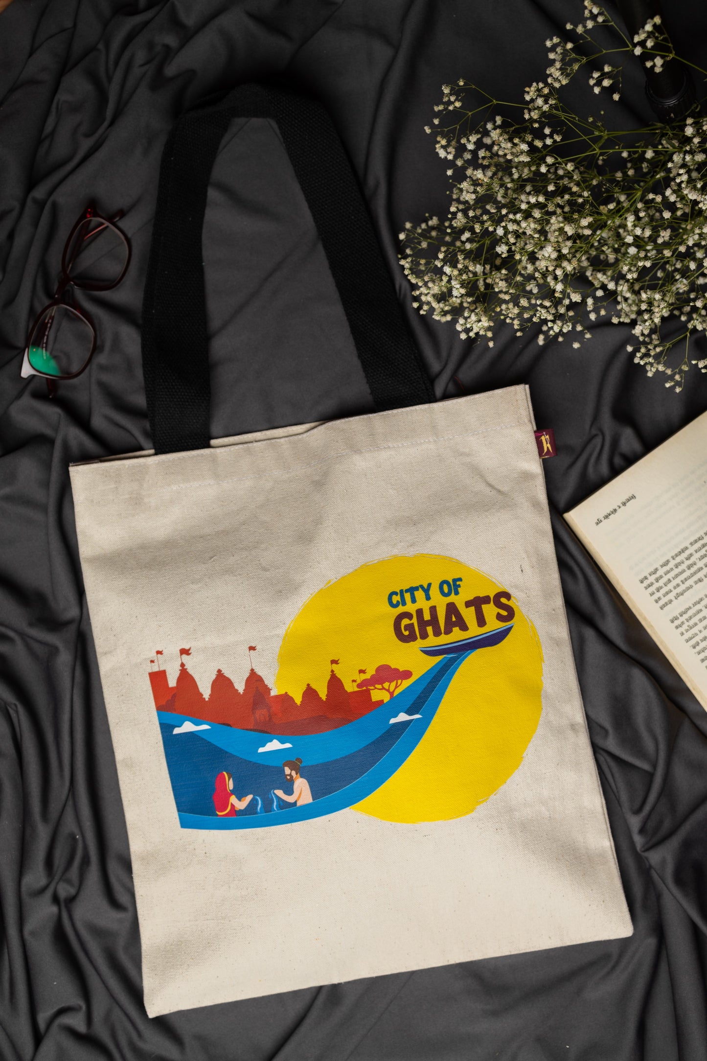 Tote bag with 'City of Ghats' design on a dark fabric background