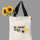 A white cotton tote bag with black handles and a graphic print that includes text and a kettlebell icon.