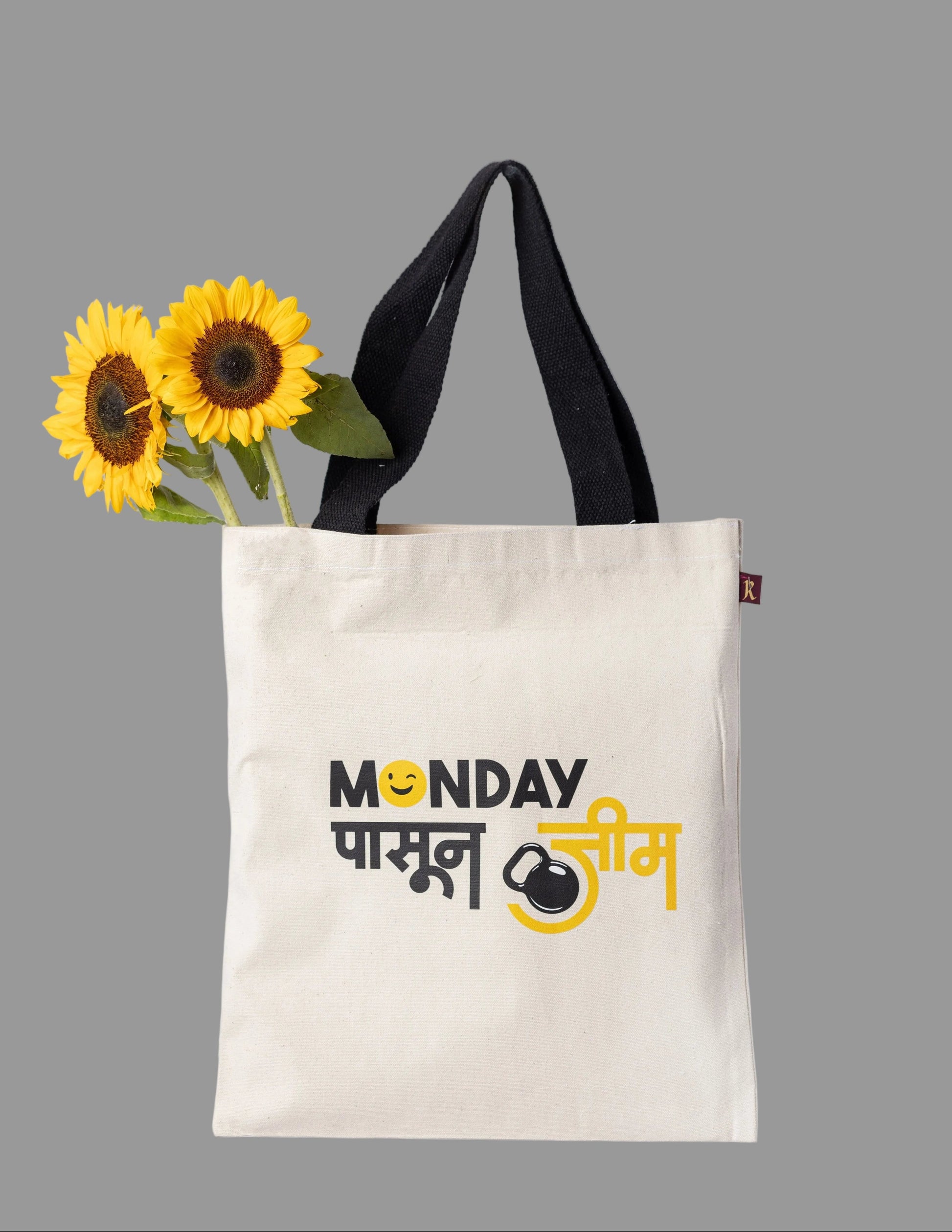 A white cotton tote bag with black handles and a graphic print that includes text and a kettlebell icon.