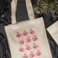 Beige tote bag with pink flamingo pattern on a dark fabric background