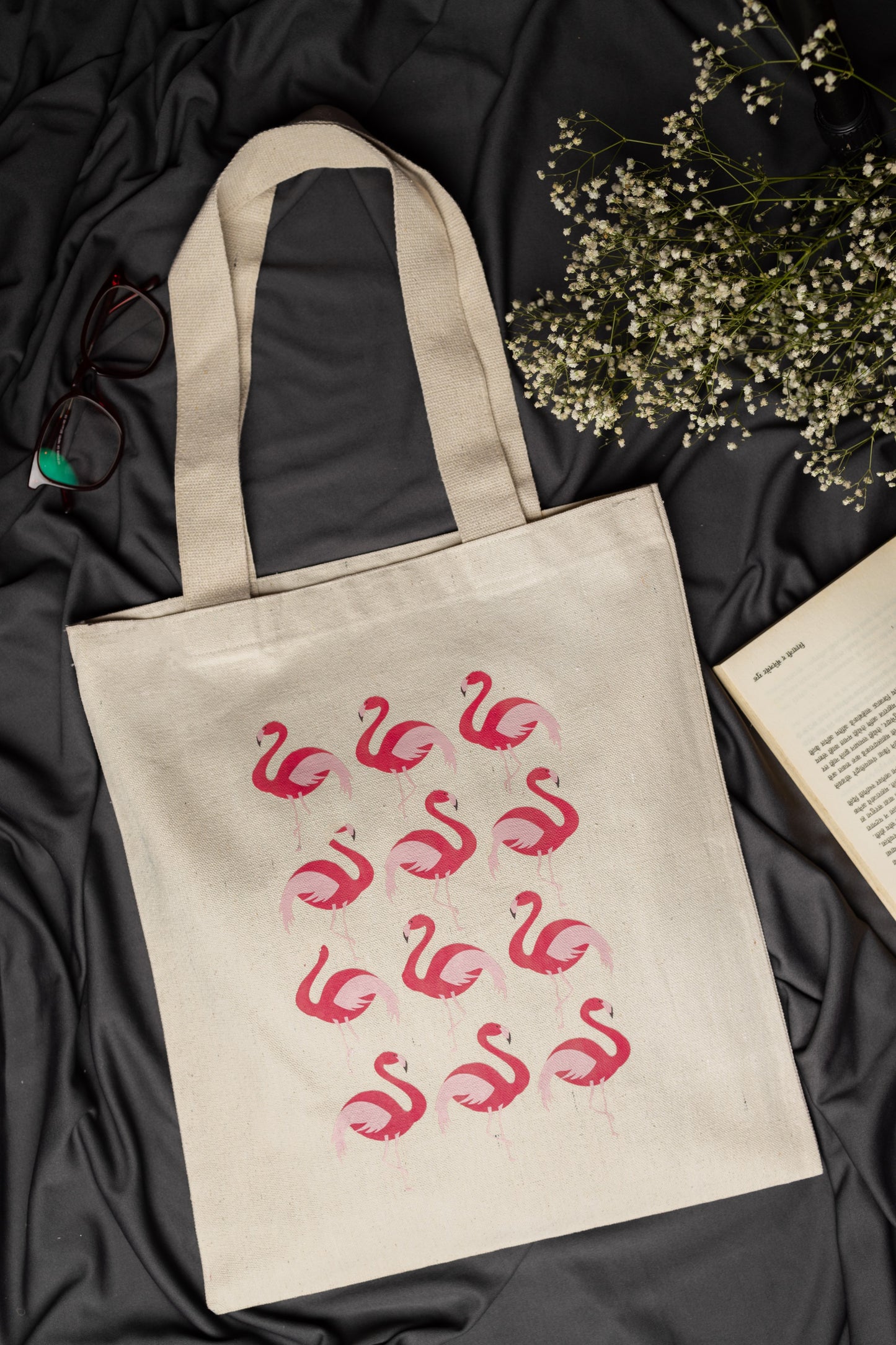 Beige tote bag with pink flamingo pattern on a dark fabric background