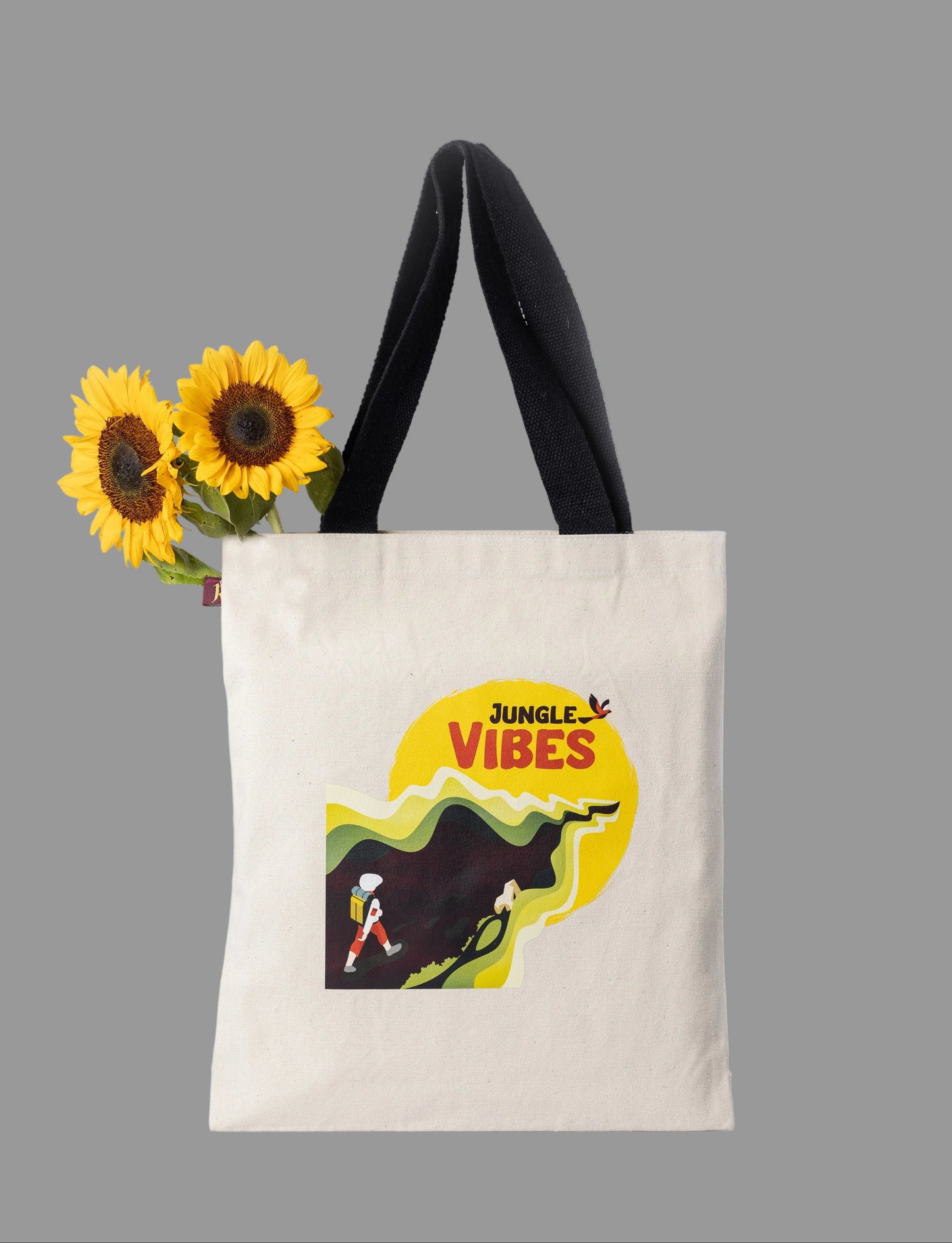 Tote bag with 'Jungle Vibes' design and sunflowers on a light gray background