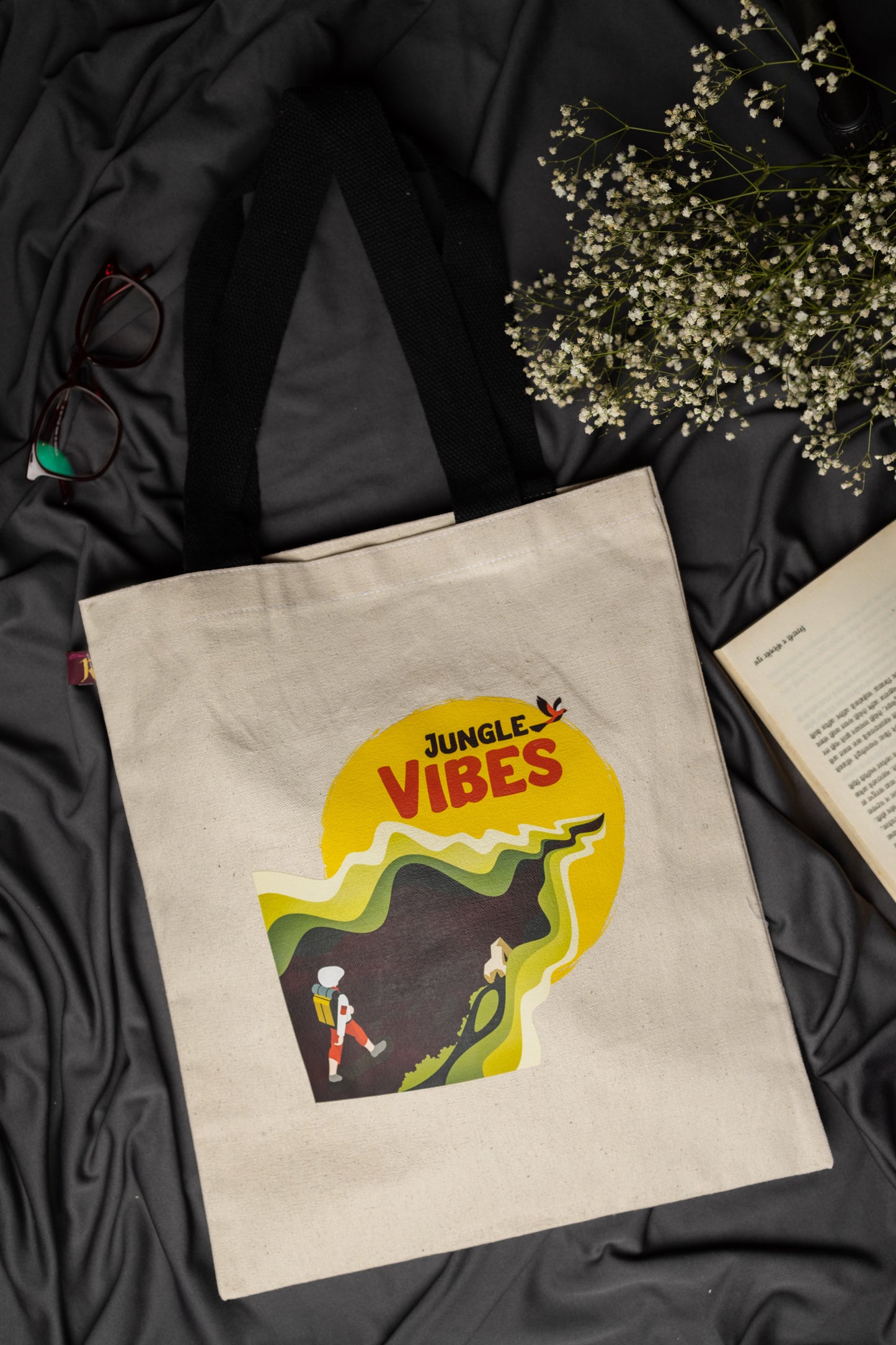 Beige tote bag with 'Jungle Vibes' design on a dark fabric background