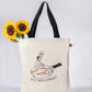 Tote bag with a graphic design of a person cooking in a pan and text 'LET HIM COOK!' 