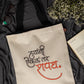 Beige tote bag with printed text on a dark fabric background