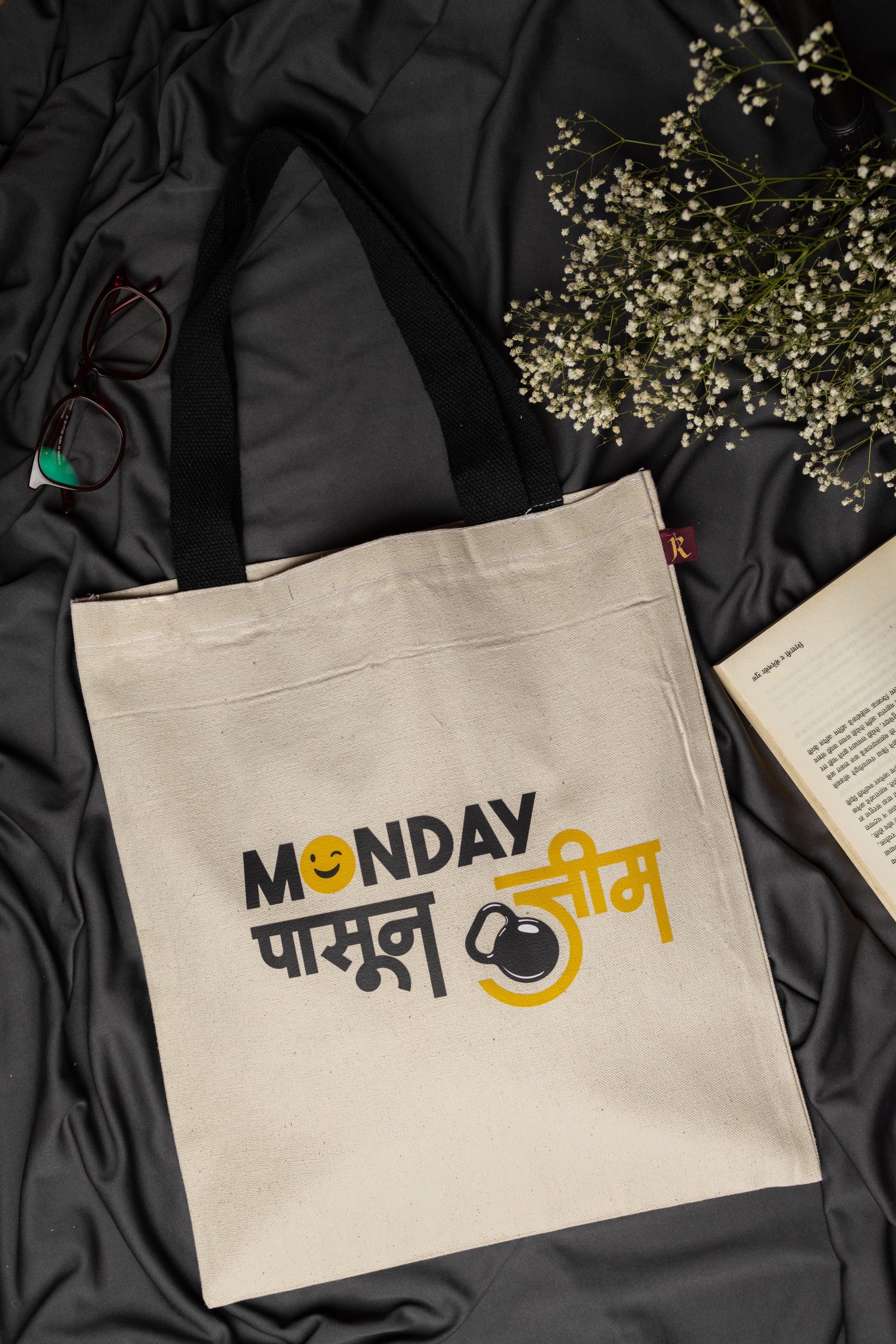 Beige tote bag with text on a black fabric background