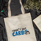 Beige tote bag with 'I Don't Eat Carbs' text on a dark fabric background