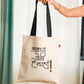 A person holding a beige flat tote bag with a black handle and a black printed text in Marathi language on the front.