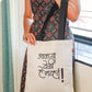 person holding a bag with Marathi typography